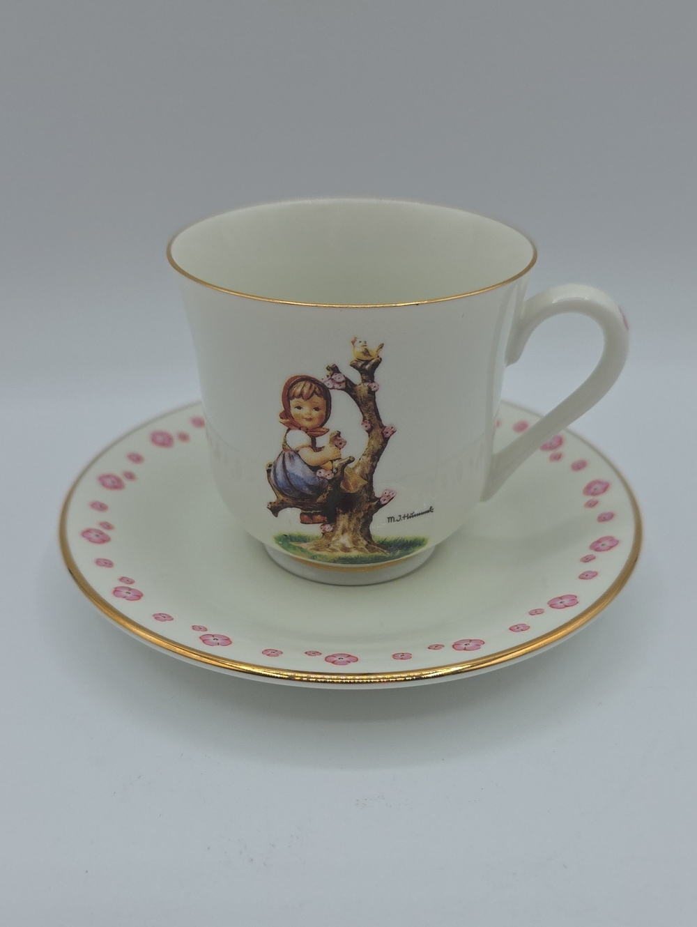 M.J. Hummel "Apple Tree Girl" White Cup Saucer Gold Trim and Pink Floral Motif